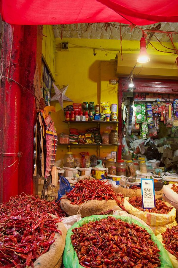 A vibrant market scene filled with various spices and dried red chilies.