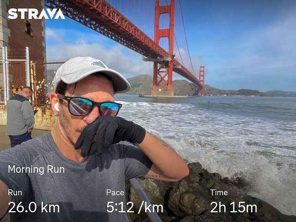 A runner poses in front of the Golden Gate Bridge after completing a morning run.