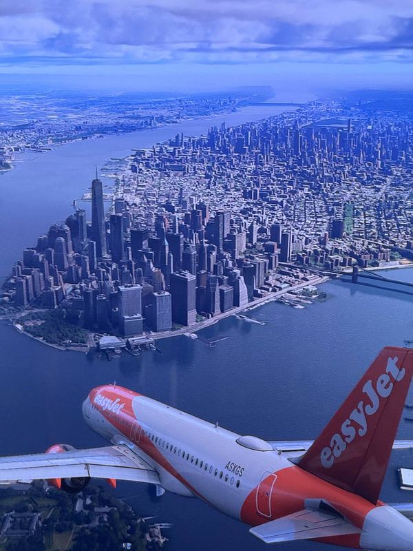 An aerial view of New York City with an easyJet airplane in the foreground.