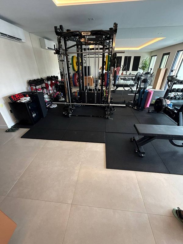 A well-equipped home gym featuring various workout equipment and a spacious layout.