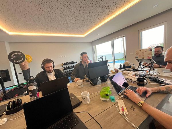 A group of individuals is engaged in a coworking session at a modern workspace.