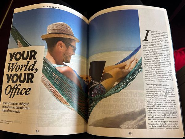 A magazine spread featuring a man relaxing in a hammock while working on a laptop, highlighting the concept of digital nomadism.
