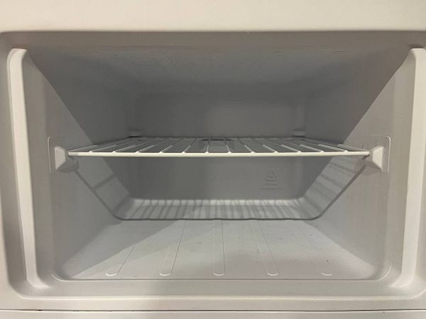An empty freezer interior with a single wire shelf.