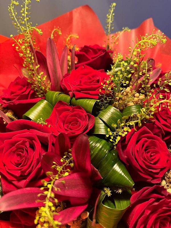 A vibrant bouquet of red roses and greenery.