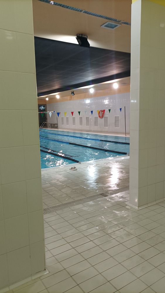 An indoor swimming pool area is visible from a tiled entrance.