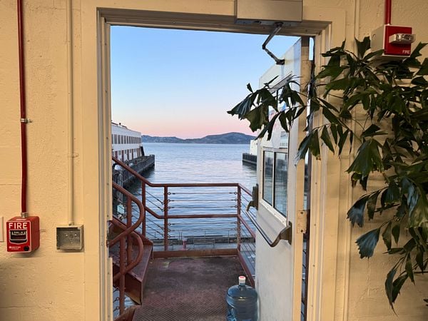 A view from an office doorway overlooking a calm body of water and distant hills.