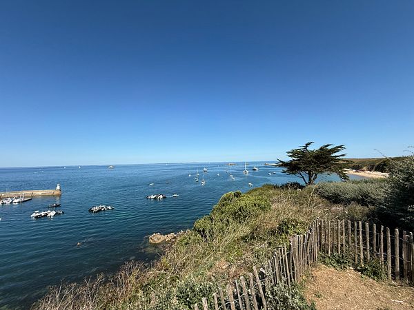 A serene coastal view featuring boats and clear blue skies.