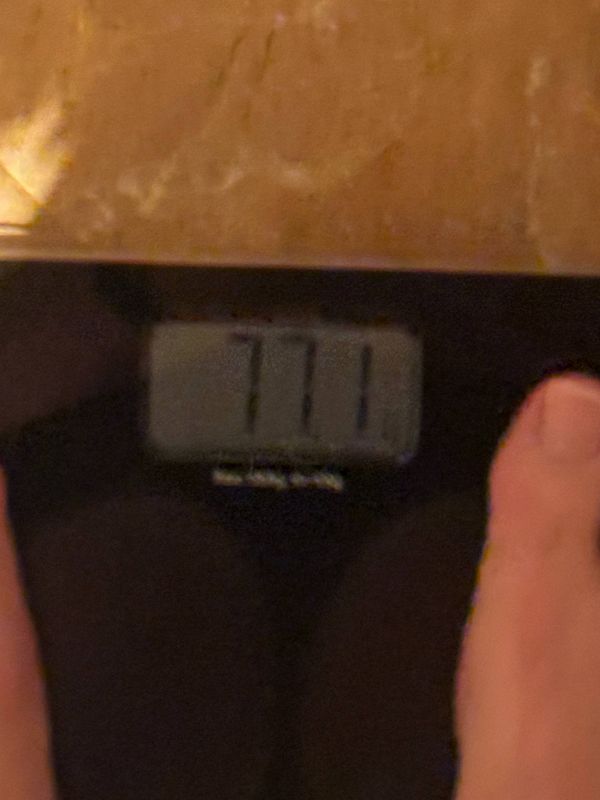 The image displays a digital scale reading 77.1 kg.