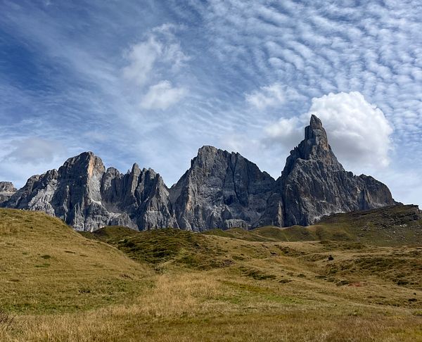 A stunning mountain landscape featuring rugged peaks under a partly cloudy sky.