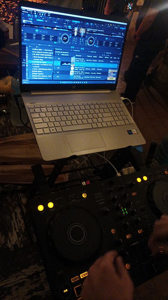 A DJ setup featuring a laptop and a DJ controller, with a focus on music mixing.