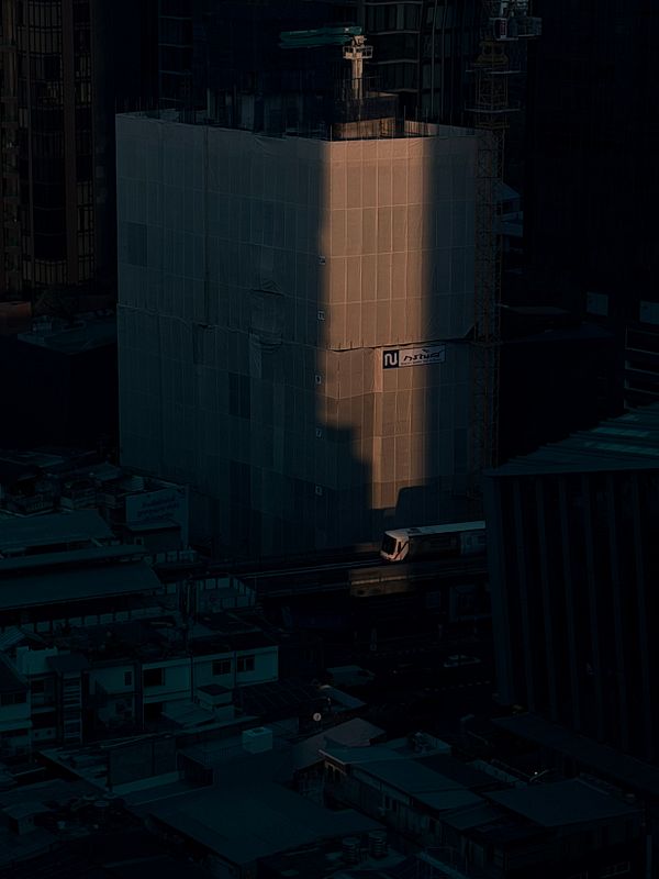 A cozy living room with a decorated Christmas tree next to a modern window wall and a comfortable beige sofa with pillows.