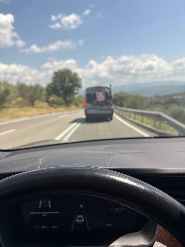 A view from the driver's seat of a car on a Slovenian road, following a van.