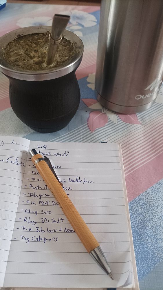 A workspace setup featuring a traditional mate drink, a thermos, and a to-do list.