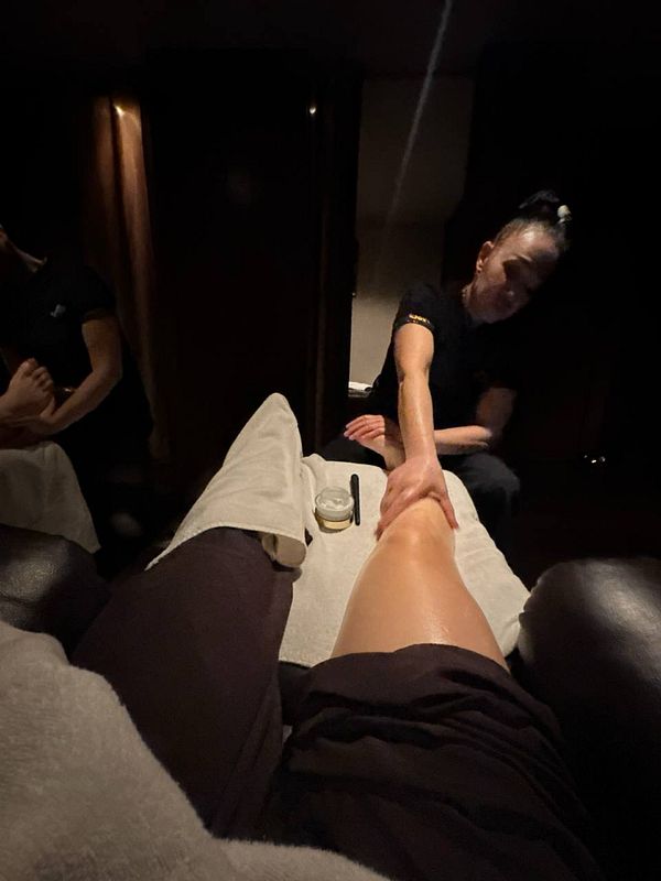 A relaxing massage session is taking place in a dimly lit room.