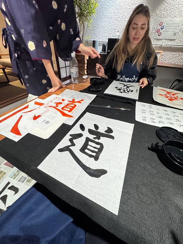A calligraphy class in Japan featuring participants practicing traditional writing techniques.