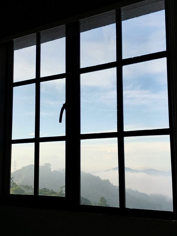 A serene view of misty mountains framed by a window.