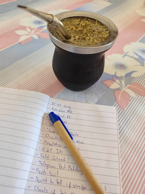 A cozy workspace featuring a laptop, coffee, and office supplies on a wooden table.