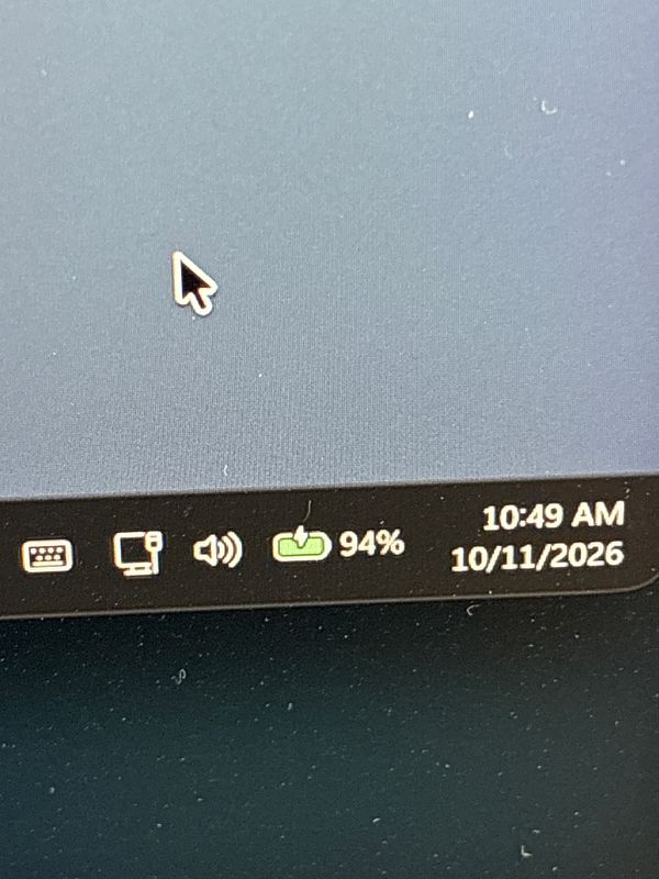 Close-up of a Windows taskbar showing battery status as 94% with a charging icon and date/time as 10:49 AM, 10/11/2026.