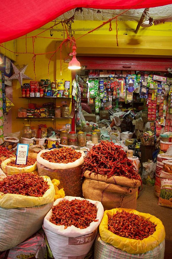 A vibrant market scene filled with colorful spices and packaged goods.
