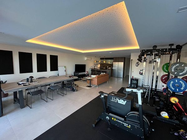 A modern coworking space featuring a gym area and a stylish meeting area.