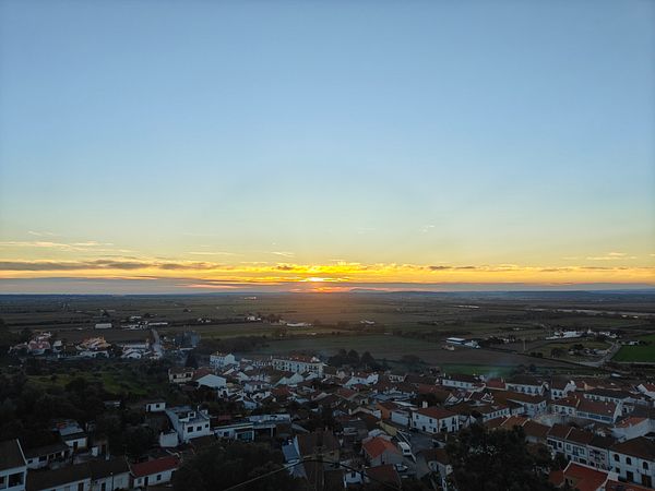 A picturesque sunset over a rural landscape with a view of a small town.