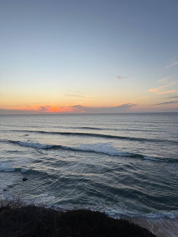 A serene coastal sunset view over the ocean.