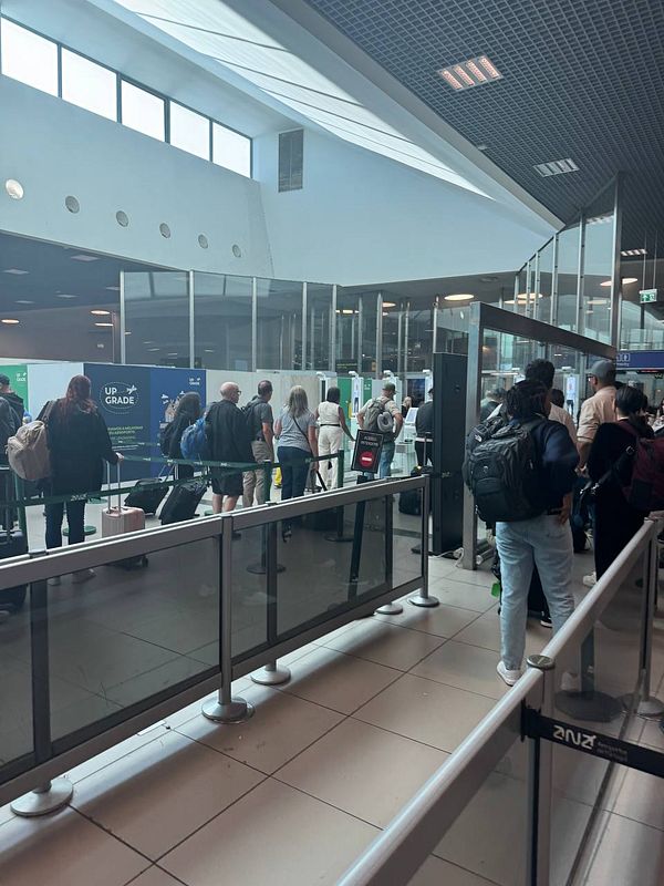 A crowded queue at Lisbon Airport's passport control area featuring new electronic gates.