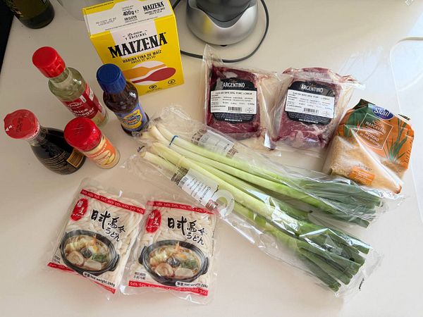 Ingredients and supplies arranged on a kitchen counter to make udon beef noodles.