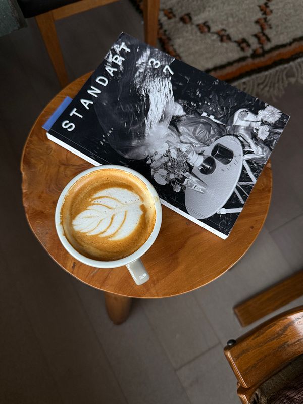 A cozy Saturday morning scene featuring a cup of coffee and a magazine on a wooden table.