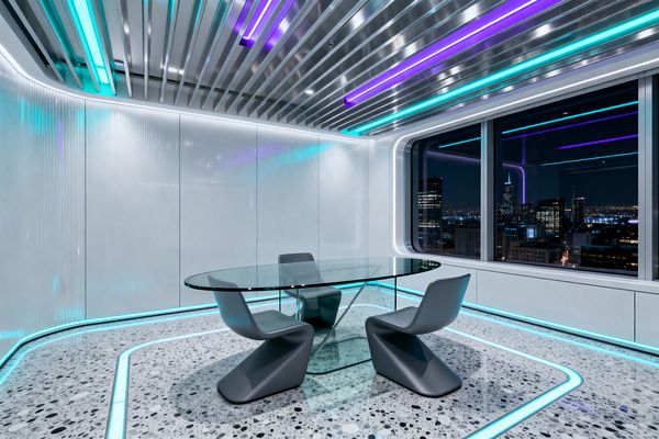 A futuristic dining room centers on an oval glass table with a transparent base, paired with two matte gray, cantilevered chairs. The speckled gray terrazzo floor contains glowing cyan light channels, while ribbed white wall panels and a metallic slatted ceiling incorporate cyan and purple LED strips. A large window with rounded corners shows a night city view as perimeter lighting washes cool light across smooth, glossy surfaces.