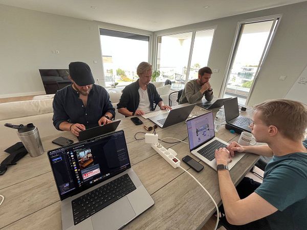 A group of four individuals is engaged in a coworking session at a modern workspace.