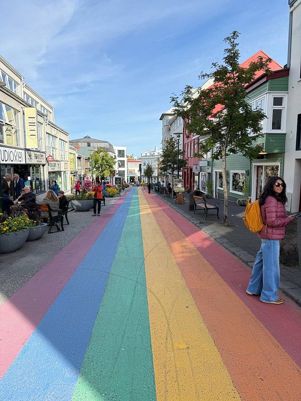 A vibrant, colorful street in Reykjavik featuring a rainbow-colored pathway.