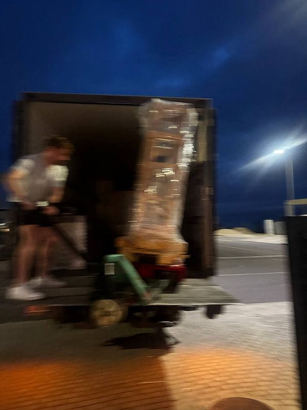 A stone table is being unloaded from a truck at night.