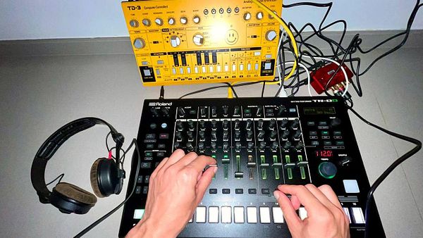 A musician is recording an acid jam using a Roland TR-8S and a Behringer TD-3 synthesizer.