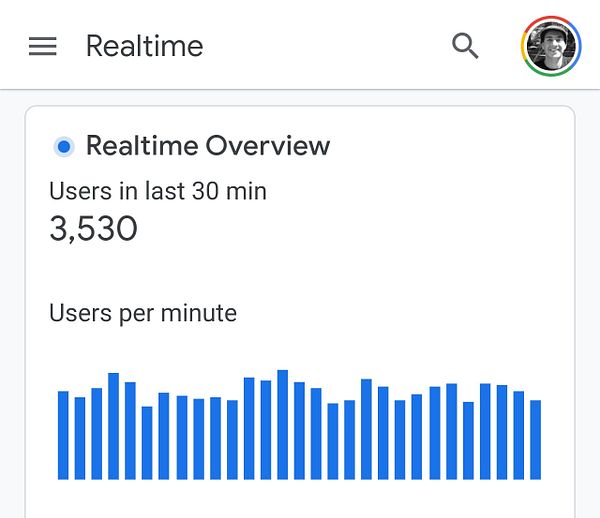 A city skyline at night showcasing illuminated skyscrapers behind a traffic juncture with moving vehicles.