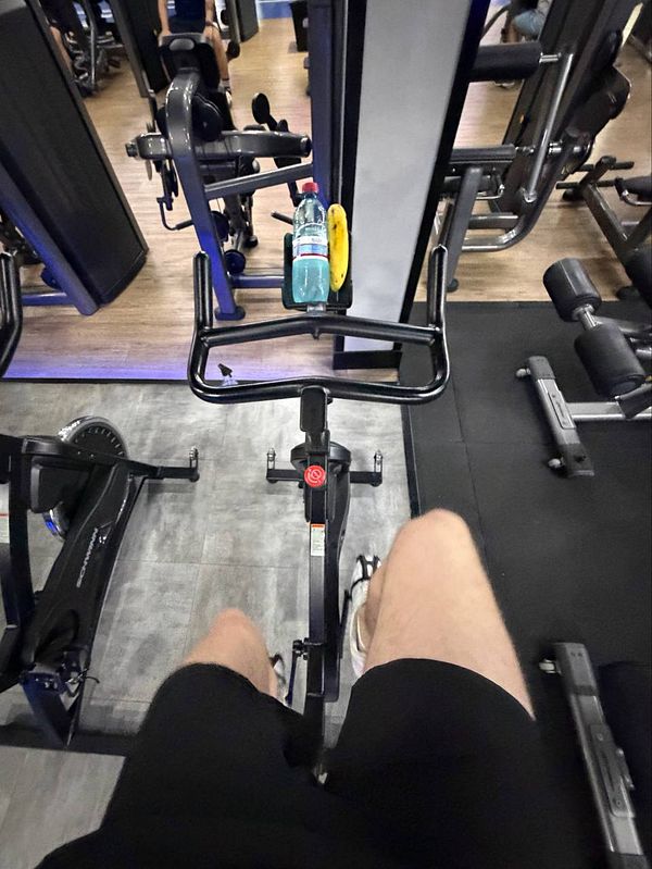 A photograph of a gym filled with various exercise equipment and individuals working out.