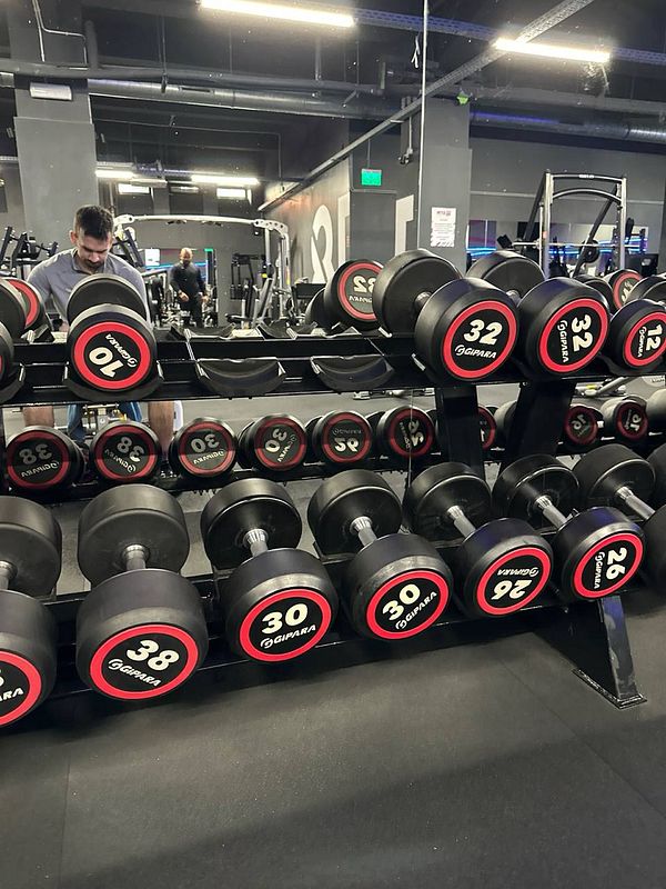 A gym setting featuring a rack of dumbbells with various weights.