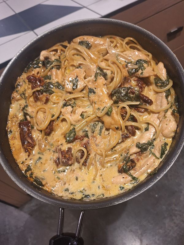 A delicious serving of Tuscan chicken pasta in a skillet.