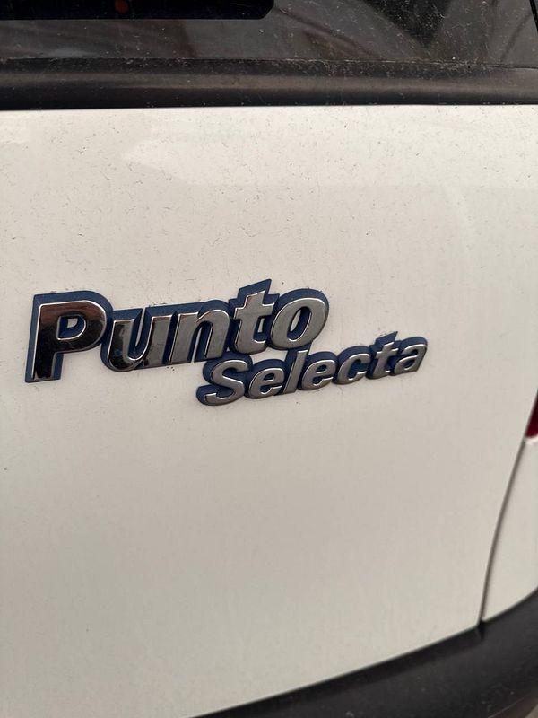 The image features the rear badge of a white car.