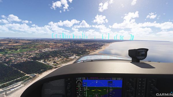 A cockpit view from an aircraft flying over Costa de Caparica, showcasing the coastline and landscape.