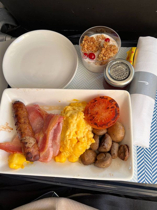A gourmet breakfast served on a flight, featuring a variety of items.