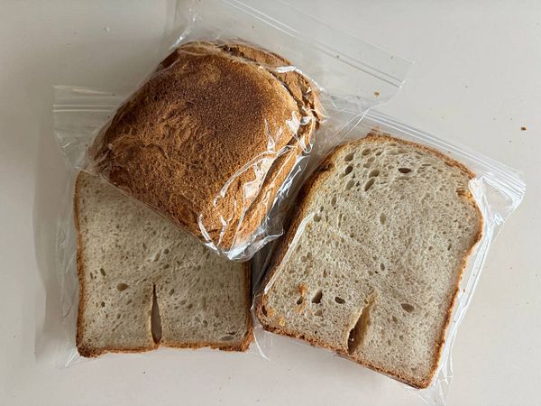 Several slices of bread individually sealed in plastic bags, prepared for freezing or storage.
