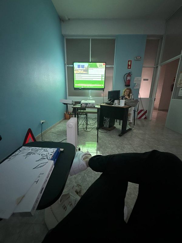 A classroom setting for a driving theory class with a projector screen displaying information.