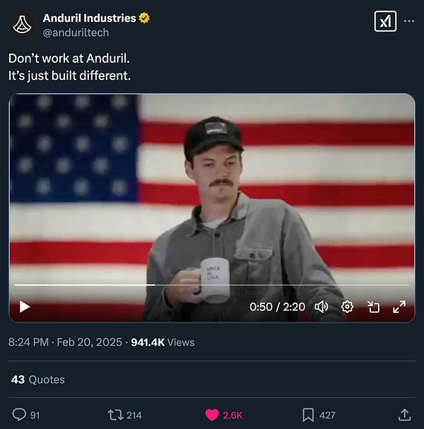 A man holding a mug stands in front of an American flag backdrop.