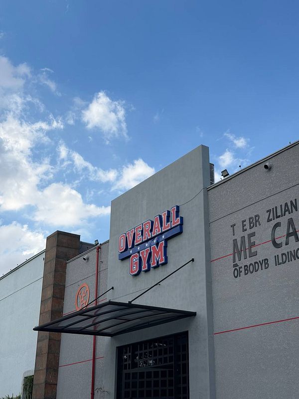 Photo of two individuals exercising on a basketball court, focusing on a gym training activity.