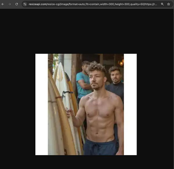 A shirtless man holding a surfboard stands in front of a group of people.