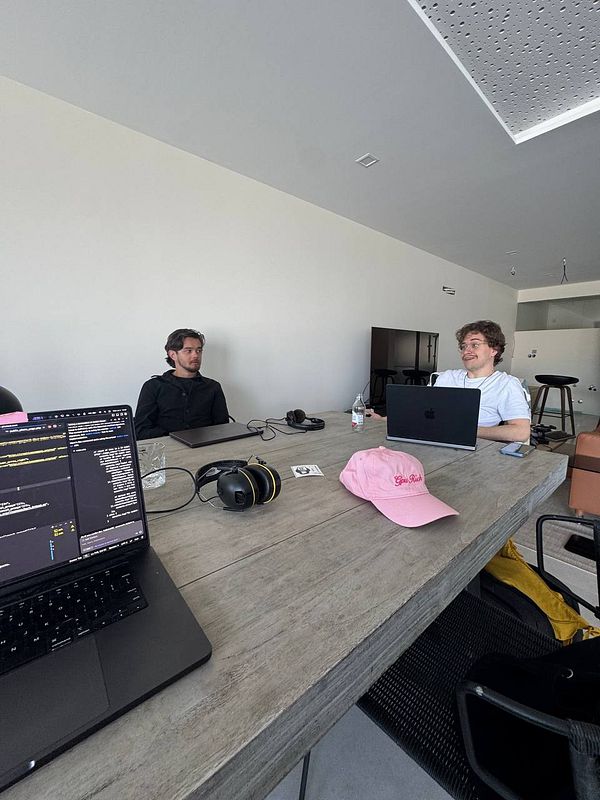 Two individuals are engaged in a coworking session at a modern workspace.