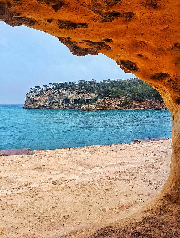 A scenic view of a coastal landscape framed by a rocky arch.