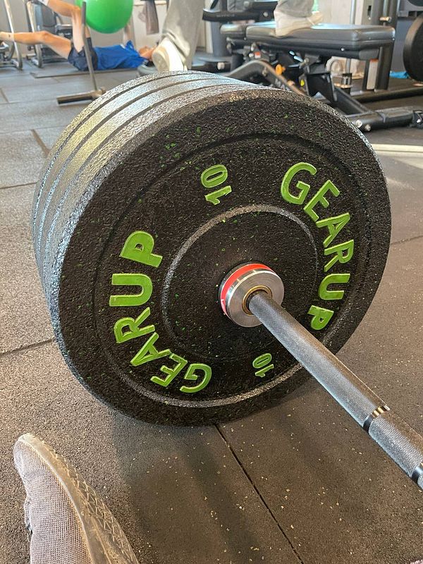A close-up view of a weight plate on a gym floor.