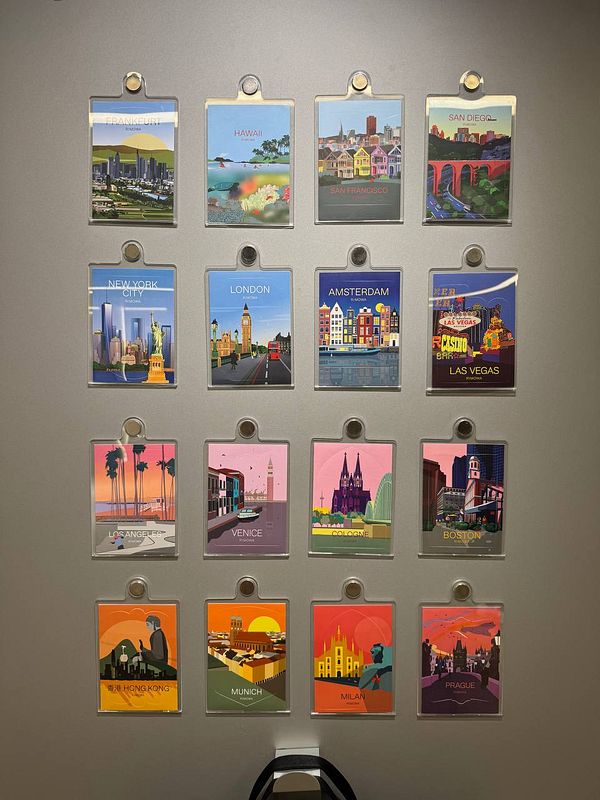 A collection of illustrated city cards displayed on a wall.